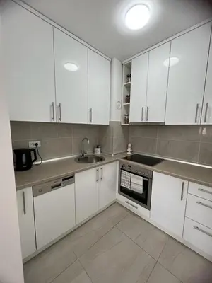 a kitchen with white cabinets and a sink at Natalija Stan na dan in Banja Luka