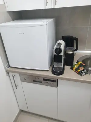 a kitchen counter with a white refrigerator next to a sink at Natalija Stan na dan in Banja Luka