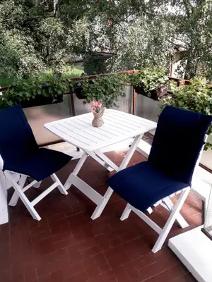 a white picnic table and two blue chairs on a patio at VIEW APARTMENT in Visoko