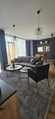 a living room with a couch and chairs and tables at Apartman Gold in Bugojno