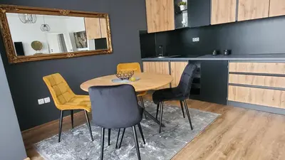 a table and chairs in a kitchen with a mirror at Apartman Gold in Bugojno