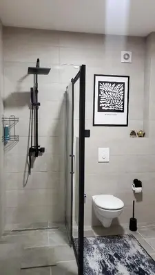 a bathroom with a toilet and a shower in it at Apartman Gold in Bugojno