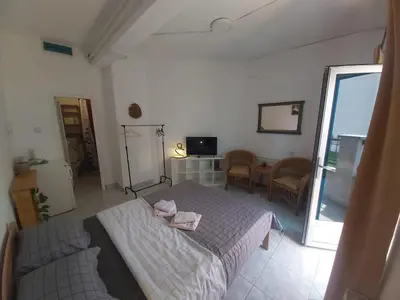 a bedroom with a bed and a living room at Apartmani Sladojević in Mrkonjić Grad