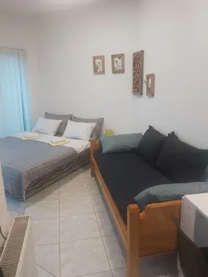 a living room with a bed and a couch at Apartmani Sladojević in Mrkonjić Grad