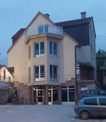 a building with a car parked in front of it at Apartmani Sladojević in Mrkonjić Grad
