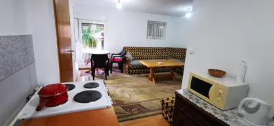 a kitchen with a stove top oven next to a living room at Vikendica Delić Lukavac in Lukavac
