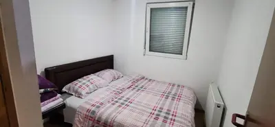 a bedroom with a bed and a window at Vikendica Delić Lukavac in Lukavac