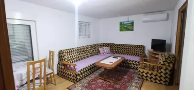 a living room with a cheetah couch and a table at Vikendica Delić Lukavac in Lukavac