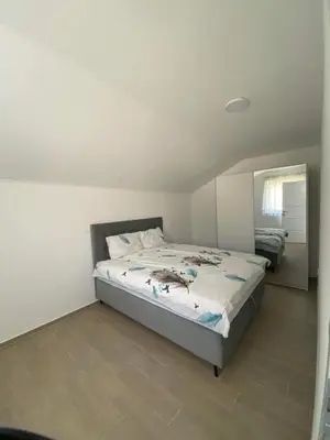 a bedroom with a bed and a mirror at Apartman Žepče in Žepče