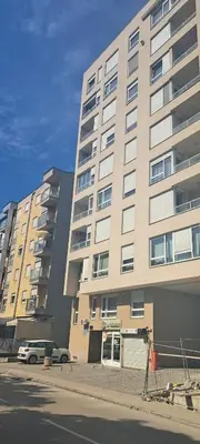 a large building with a car parked in front of it at Plazma in Banja Luka