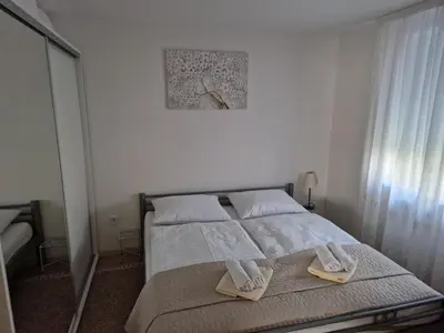 a bedroom with a bed with towels on it at Apartman Potok in Livno