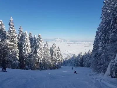 a group of people skiing down a snow covered slope at Apartman Potok in Livno