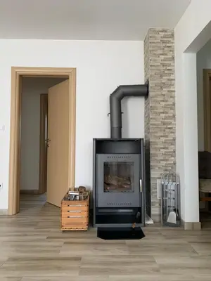 a fireplace in a living room with a brick wall at Apartman Potok in Livno