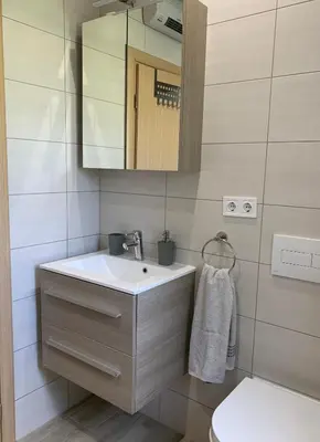 a bathroom with a sink and a mirror and a toilet at Apartman Potok in Livno