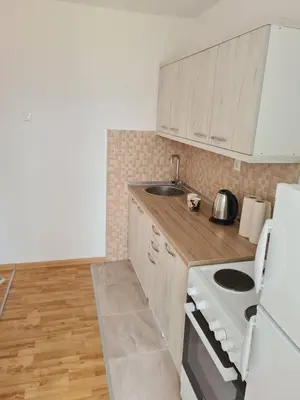 a kitchen with white cabinets and a sink and a stove at Bilino polje in Zenica