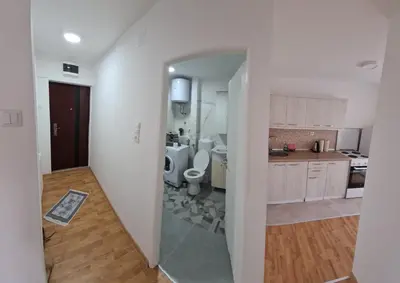 a white kitchen with a toilet and a sink at Bilino polje in Zenica