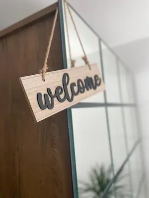 a sign that says welcome hanging in front of a window at Damade apartments in Jajce