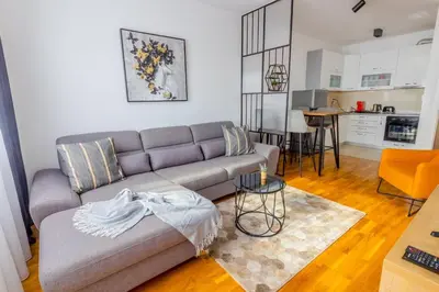 a living room with a couch and a kitchen at Platinum_Luxury_Apartment in Teslić