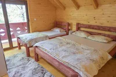 a bedroom with two beds in a log cabin at Hakuna Matata Lake House in Jajce