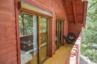 a porch of a log cabin with glass windows at Hakuna Matata Lake House in Jajce