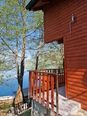 a wooden porch of a cabin with a view of a lake at Hakuna Matata Lake House in Jajce