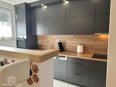 a kitchen with gray cabinets and a wooden counter top at Apartment Deluxe in Jajce