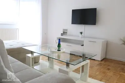 a living room with a glass table and a television at Apartment Deluxe in Jajce