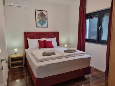 a bedroom with a bed with red pillows on it at Holiday Home Libera in Bihać