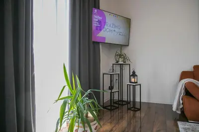 a living room with a tv hanging on the wall at Holiday Home Libera in Bihać