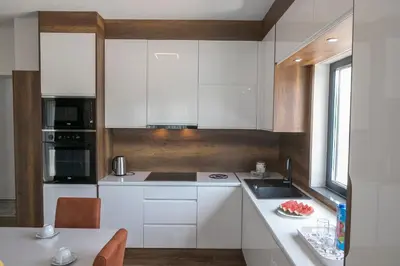 a white kitchen with white cabinets and a table at Holiday Home Libera in Bihać