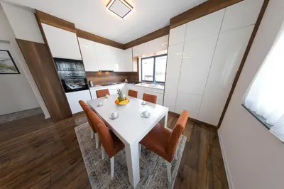 a kitchen and dining room with a white table and chairs at Holiday Home Libera in Bihać