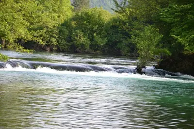 a river with rapids and trees in the background at Villa River and Sky in Bihać