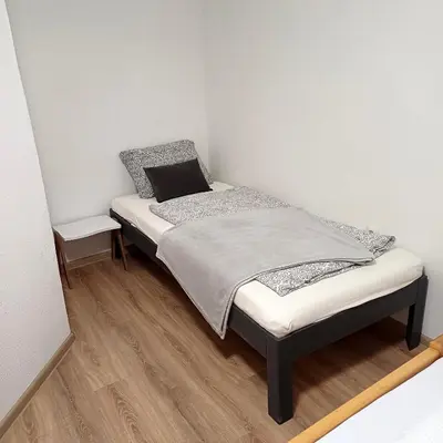 a small bedroom with a bed in the corner at Rose Apartment in Jajce