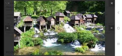 a group of wooden huts next to a river at Rose Apartment in Jajce
