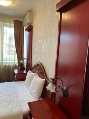 a hotel room with a bed and a red wall at Hotel Kamel in Banja Luka
