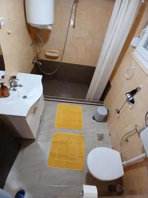 a bathroom with a sink and a toilet and a shower at Apartment View in Jajce