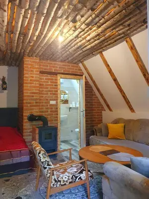 a living room with a couch and a wood stove at Etno selo BISTROVO in Vitez