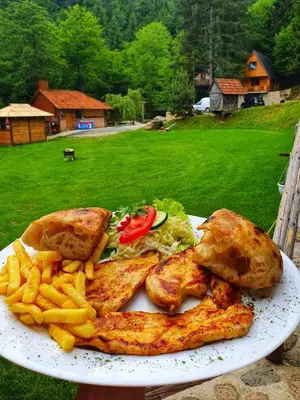 a plate of food with chicken and french fries at Etno selo BISTROVO in Vitez