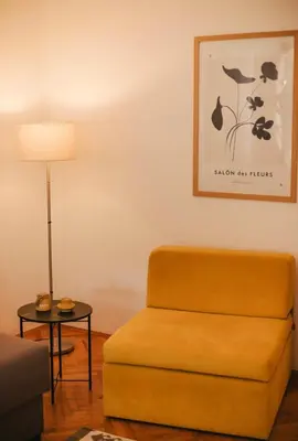 a living room with a chair and a lamp at Apartman sunce Visoko in Visoko
