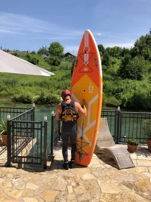 a man is standing next to a surfboard at Sokograd Attic in Šipovo
