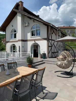 a house with a table and chairs and an umbrella at Sokograd Attic in Šipovo
