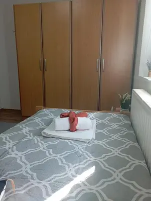 a bedroom with a bed with a teddy bear on a towel at Apartman U&O Bihać in Bihać