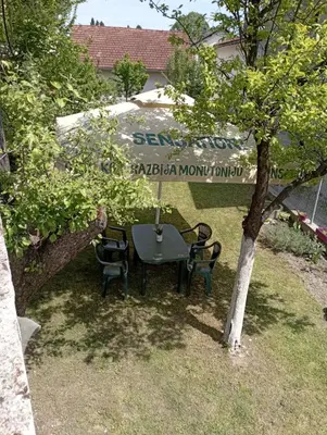 a table and chairs under a tree in a yard at Apartman U&O Bihać in Bihać