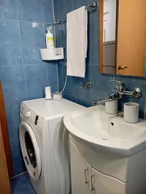 a bathroom with a washing machine and a sink at Apartman U&O Bihać in Bihać