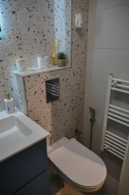 a bathroom with a white toilet and a sink at Studio apartman NEI in Tuzla