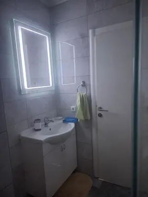 a white bathroom with a sink and a window at Apartman Knežević in Donja Varoš