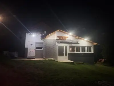 a house with lights on the side of it at night at Vikendica Avram-Plane in Plane