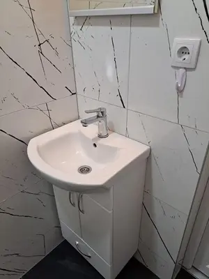 a white sink in a bathroom with marble walls at Vikendica Avram-Plane in Plane
