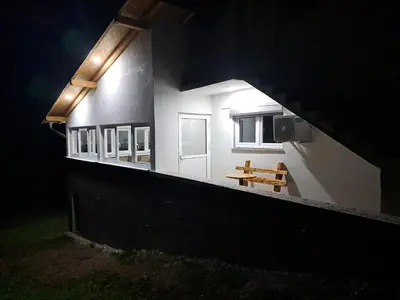 a view of a house at night with a bench at Vikendica Avram-Plane in Plane