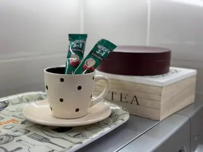 a coffee cup with toothbrushes and a box on a table at STENI Apartman in Doboj